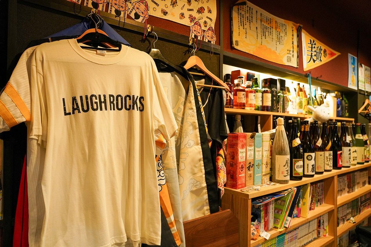 店内に飾られたTシャツとユニフォーム、酒瓶の棚