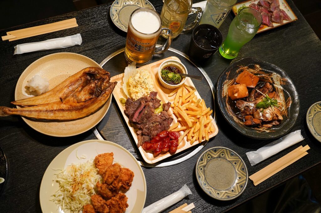 テーブルに並んだ居酒屋料理とビール